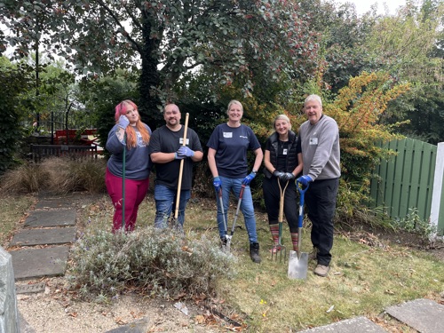 five people from Volker Rail Volunteering at Doncaster Deaf Trust stood with gardening tools